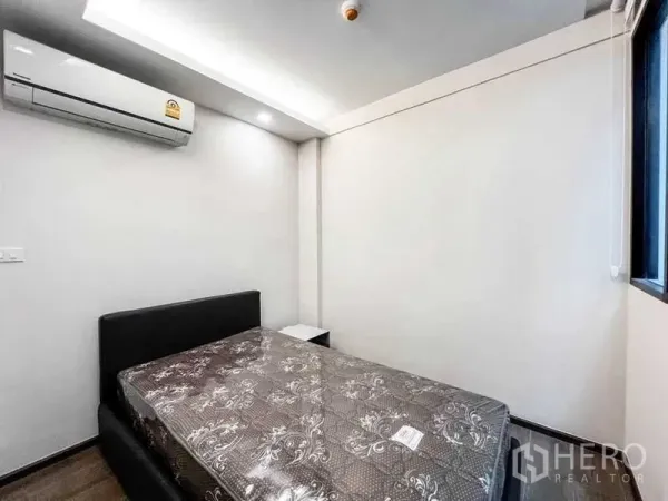 คอนโด ขายในHuai Khwang, Bangkok - ห้องนอนขนาดกะทัดรัด พร้อมเตียงคู่ เครื่องปรับอากาศ ผนังสีขาว และหน้าต่างรับแสงธรรมชาติ