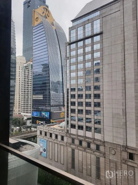 公寓 出租在Pathum Wan, Bangkok - 从公寓窗外望向曼谷市中心天际线与现代写字楼景观。