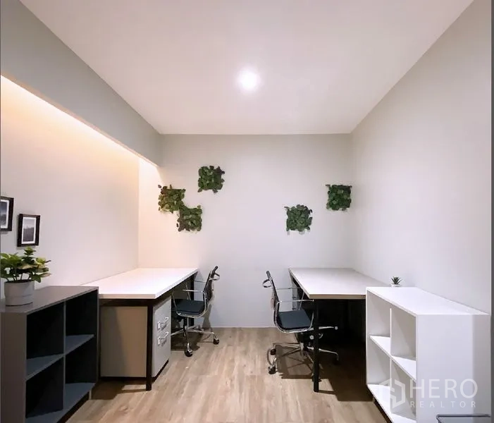 Office Space for rent in Bang Rak, Bangkok - Small private room with two corner desks, shelving, swivel chairs, and wall greenery.