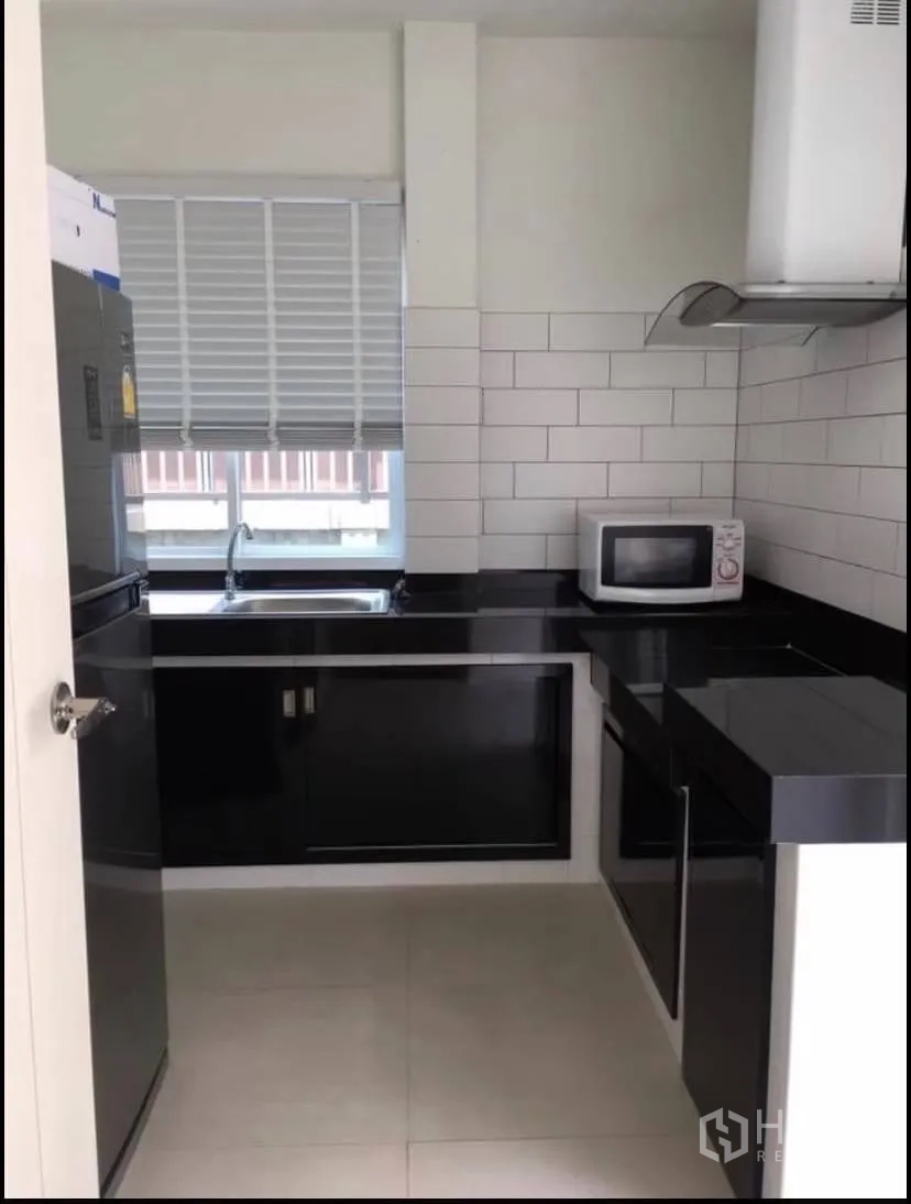 Detached House for rent or sale in Prawet, Bangkok - Enclosed Thai kitchen with black countertops, white subway tiles and a window.