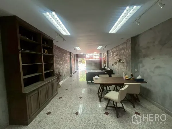 店屋 出租在Bang Rak, Bangkok - 由后往前的店内视角，内置柜、工作桌与前方卷闸门。