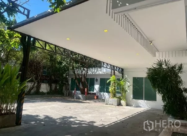สำนักงานที่บ้าน ให้เช่าในWatthana, Bangkok - โรงจอดรถมีหลังคาพร้อมไฟดาวน์ไลท์ และทางเข้าจอดรถกว้างล้อมด้วยต้นไม้