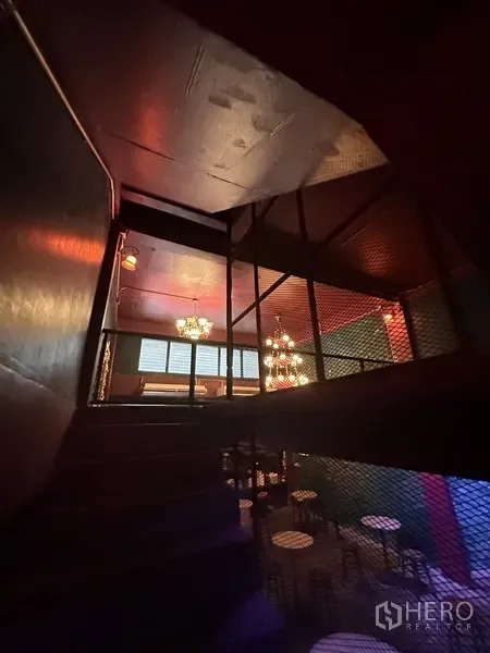 零售空间 出租 - 楼梯通往夹层，金属网栏与工业风照明。