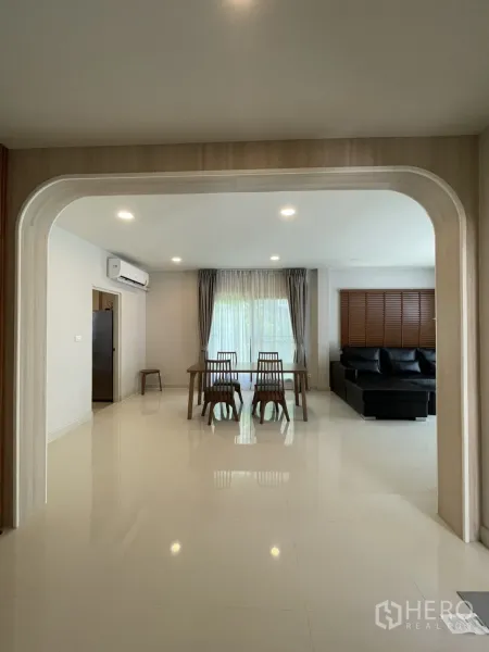 独立式住宅 出租在Bang Phli, Samut Prakan - 拱形门框视角，可见餐桌与大窗客厅。