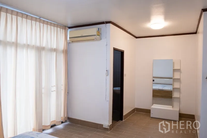 Home Office for rent in Khlong Toei, Bangkok - Bedroom corner with ensuite doorway, mirror and shelving.