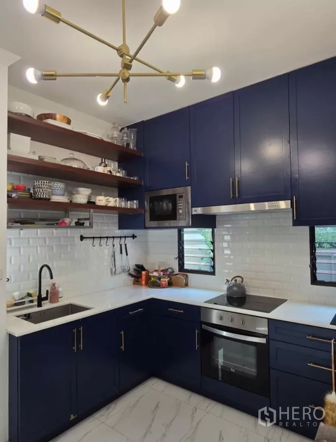 Detached House for rent in Bang Phli, Samut Prakan - U-shaped kitchen with navy cabinets, white subway tiles, oven and open shelves