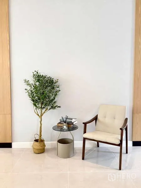 Detached House for rent or sale in Bang Phli, Samut Prakan - Minimalist reading nook with upholstered chair, side table and indoor plant.