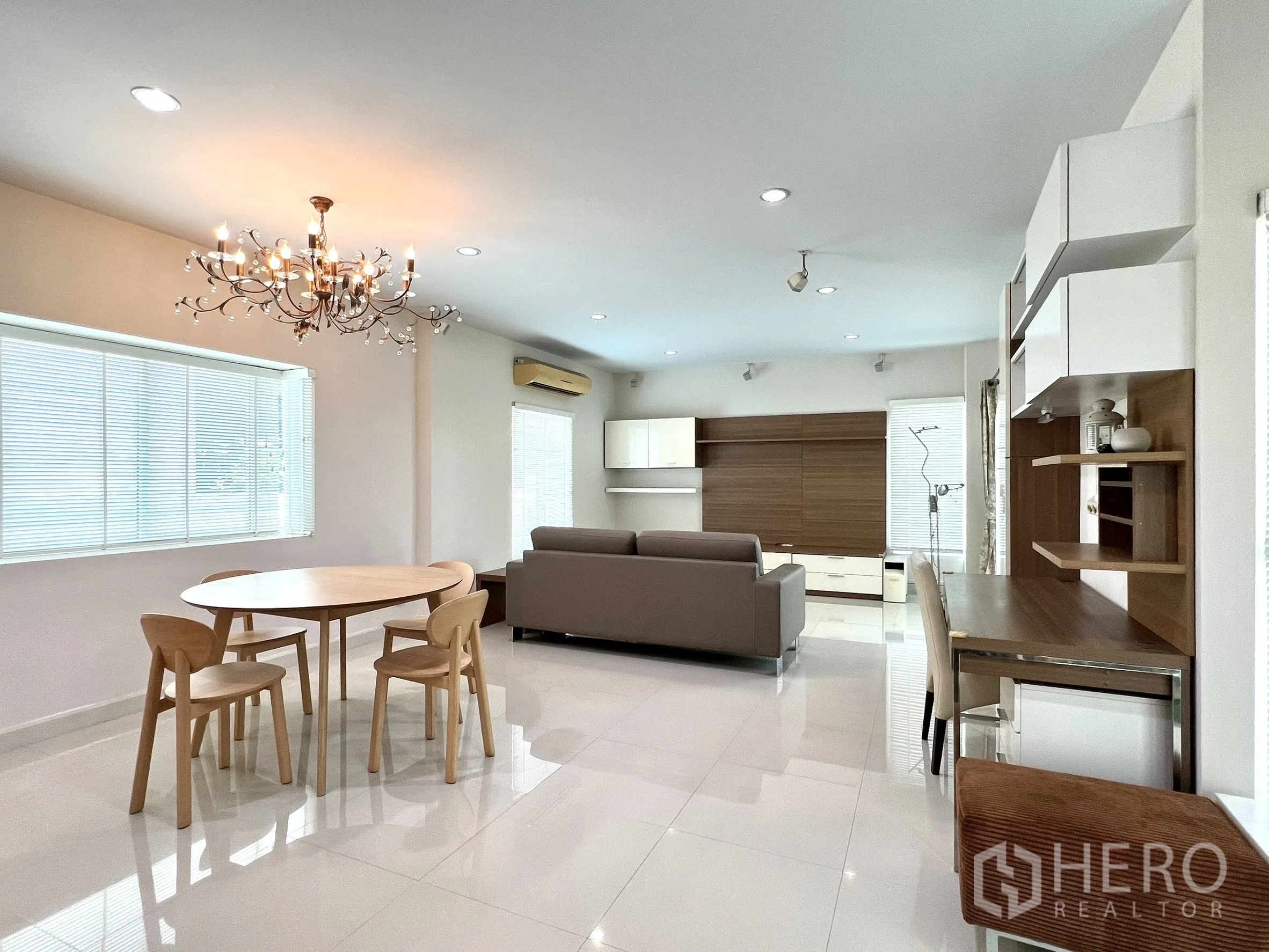 独立式住宅 出租或出售在Saphan Sung, Bangkok - 宽敞起居区，圆餐桌、沙发和墙面柜体。