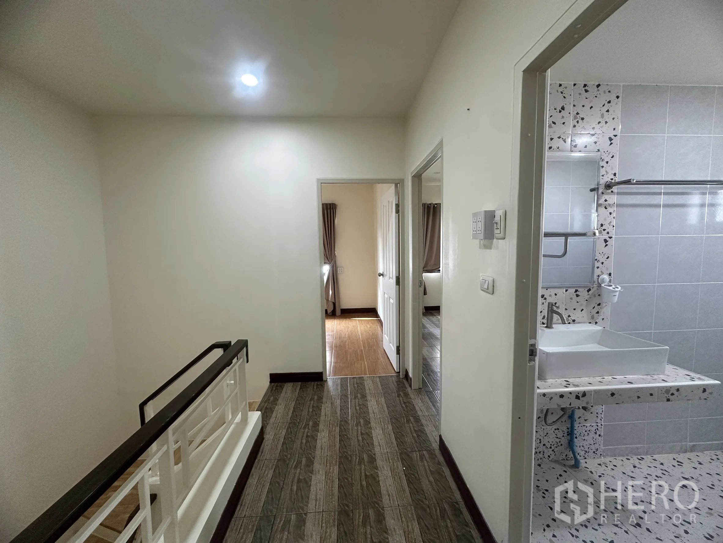 Townhouse for sale in Lam Luk Ka, Pathum Thani - Upstairs hallway and staircase landing leading to bedrooms and bathroom.