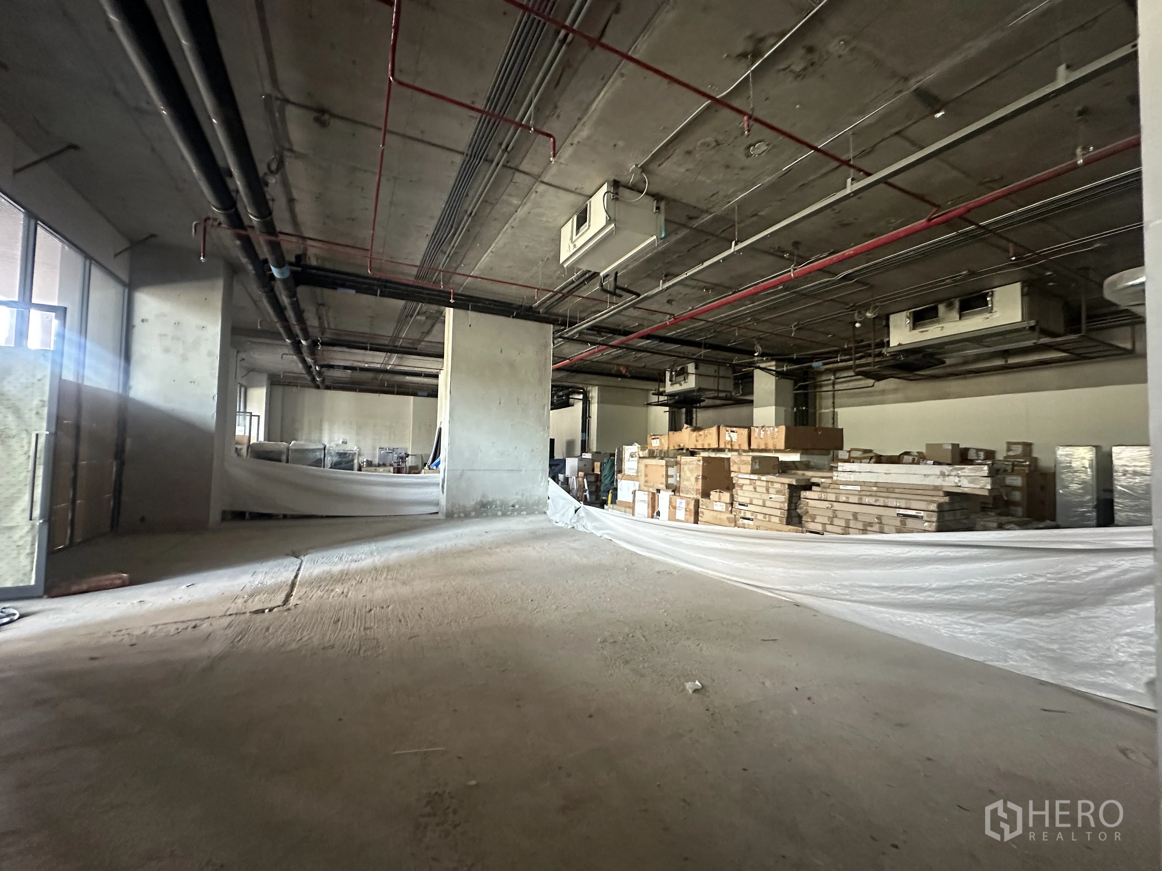零售空间 for rent in Khlong Toei, Bangkok - 大开间零售区，施工现场可见混凝土柱与堆放的材料。