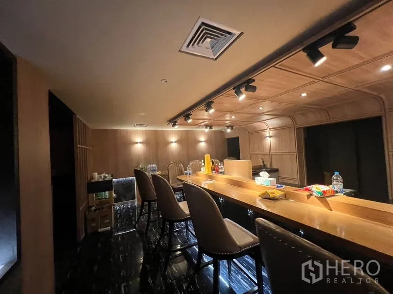 Retail Space for rent in Bang Rak, Bangkok - Bar area with wood ceiling, spotlighting, and high stools over dark flooring.