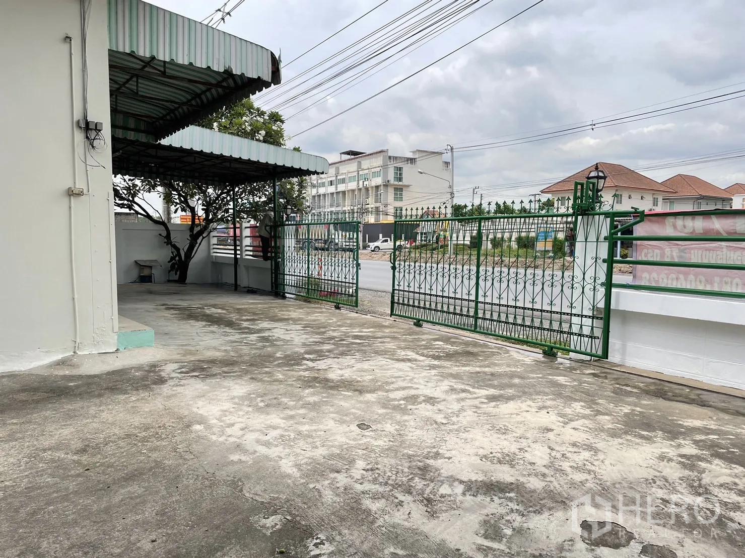 工厂 出租或出售在Pathum Thani - 前院与绿色滑动大门，面向主干道。