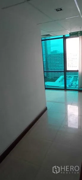 สำนักงาน ให้เช่าในHuai Khwang, Bangkok - ทางเชื่อมไปมุมหน้าต่าง เห็นวิวสกายไลน์และป้ายทางออกฉุกเฉิน