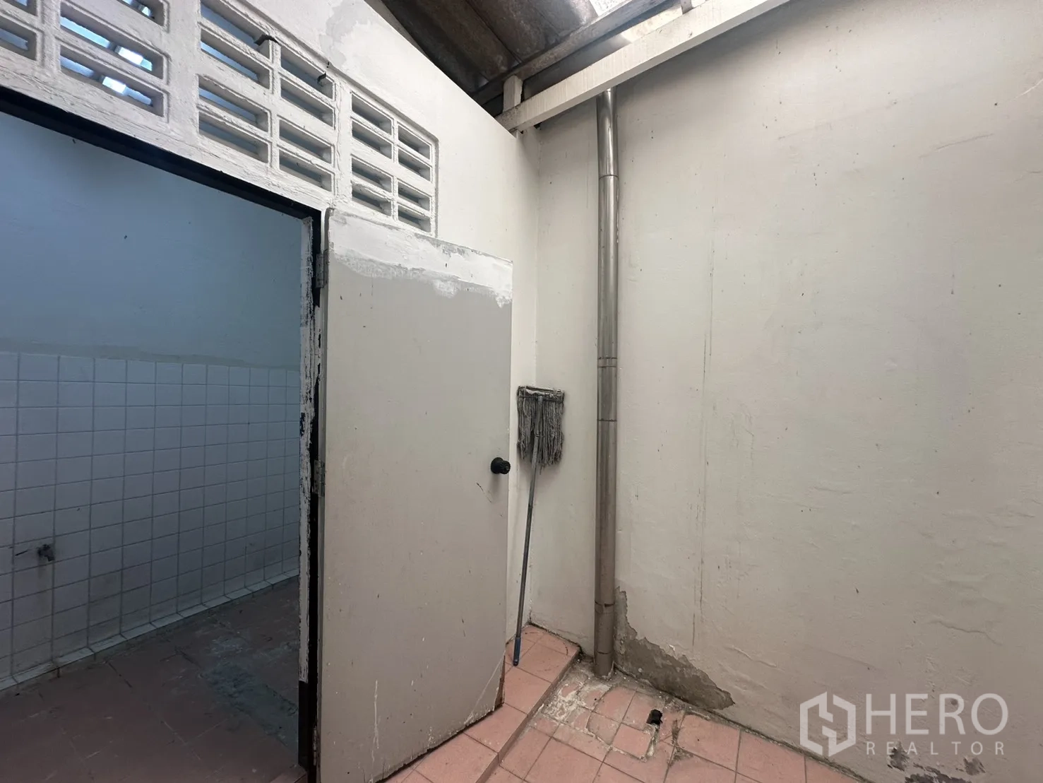 โฮมออฟฟิศ for rent in Watthana, Bangkok - โซนซักล้างด้านหลังพื้นกระเบื้องพร้อมประตูห้องเอนกประสงค์.