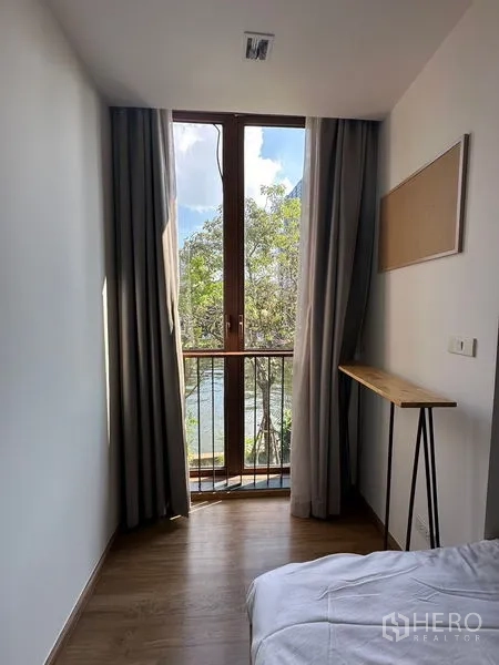 Condominium for rent in Watthana, Bangkok - Narrow window nook with French-style balcony and leafy view outside.