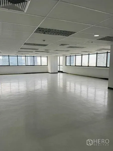 办公空间 出租或出售在Phaya Thai, Bangkok - 转角办公区配大幅窗景与城市视野，白色地面与嵌入式照明。