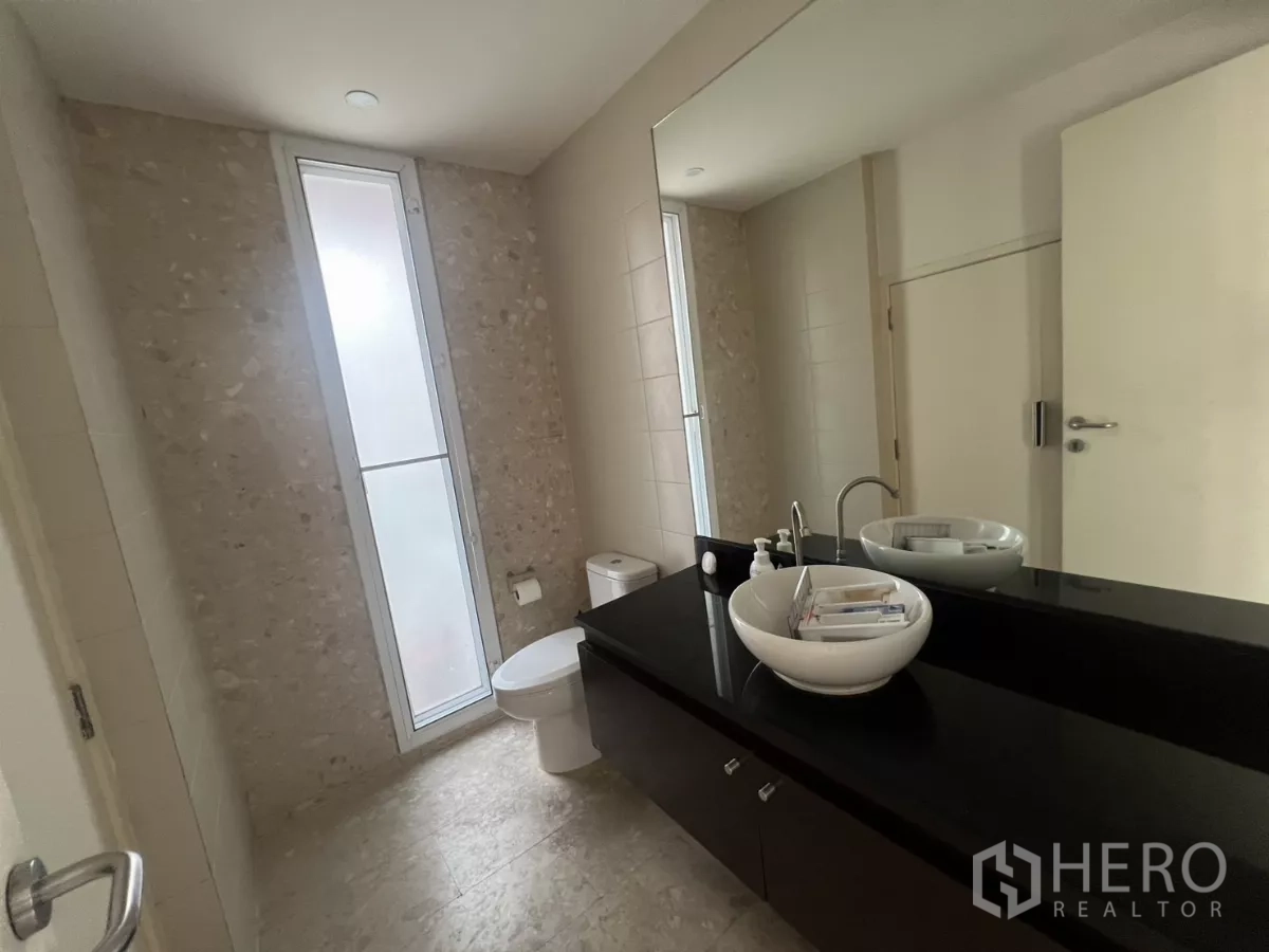 Detached House for rent in Wang Thonglang, Bangkok - Modern bathroom with long vanity, vessel sink and a frosted window.