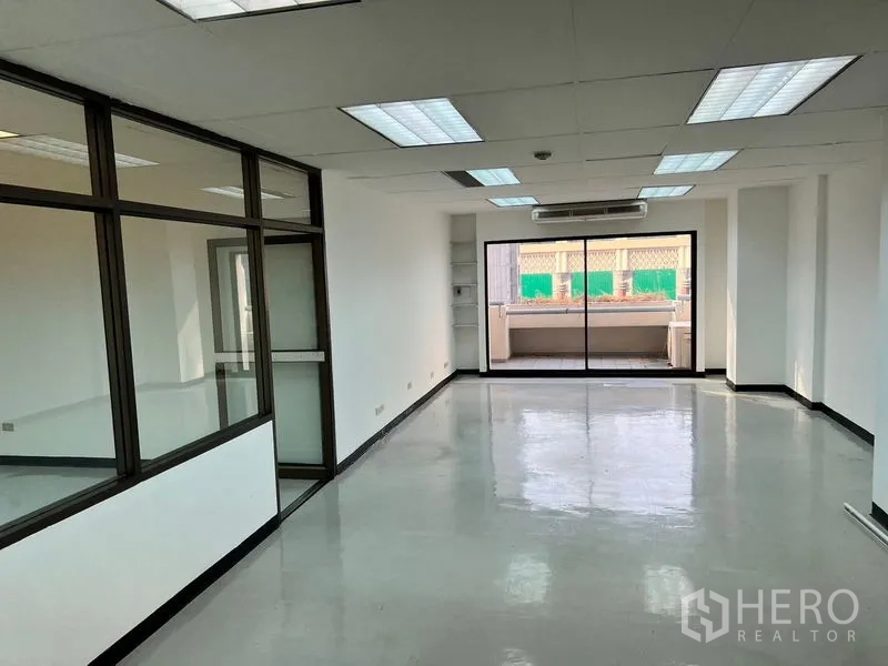 办公空间 出租在Pathum Wan, Bangkok - 明亮开放式办公室，抛光地面、荧光灯、壁挂空调，推拉玻璃门通向阳台。