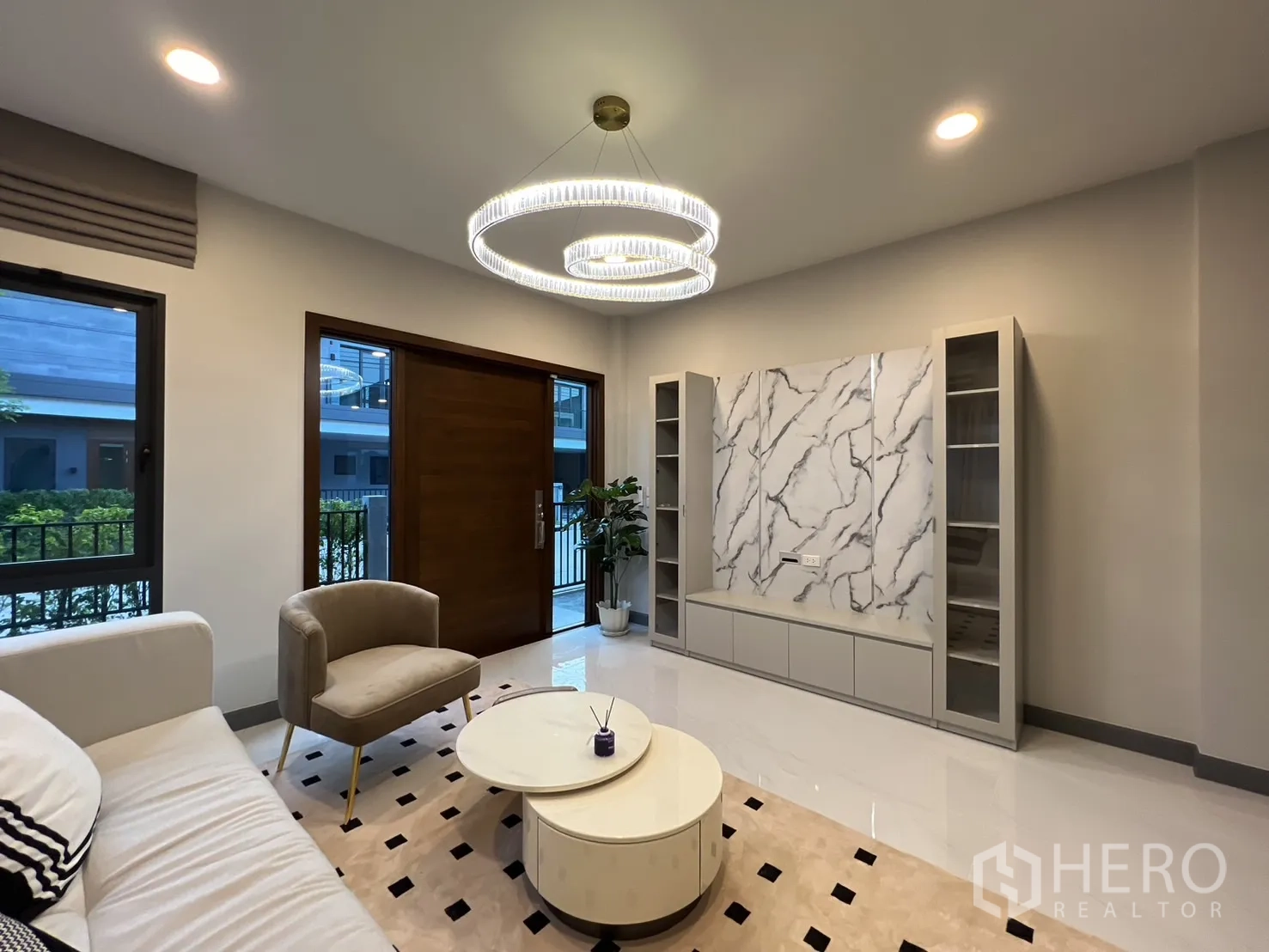 Detached House for rent in Bang Phli, Samut Prakan - Lounge with marble feature TV wall and glossy floor tiles.