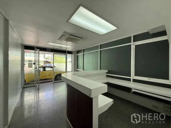办公空间 出租在Bueng Kum, Bangkok - 接待区朝向玻璃入口，带内置工作台与吊顶空调