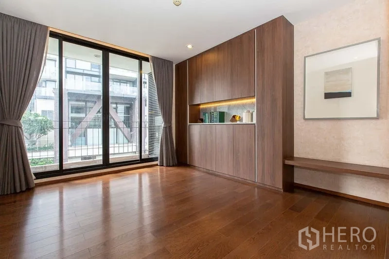 Condominium for sale in Sathon, Bangkok - Flexible room with built-in cabinetry and sliding glass doors overlooking a courtyard.