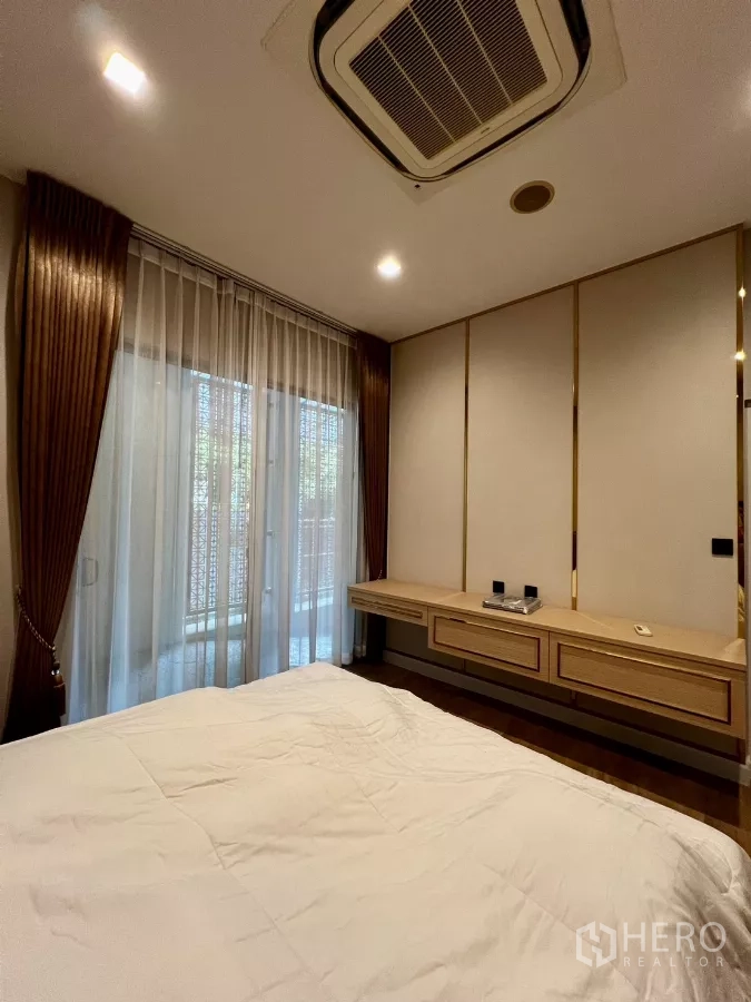 Detached House for rent or sale in Prawet, Bangkok - Guest bedroom with built-in floating desk and sliding door to balcony.