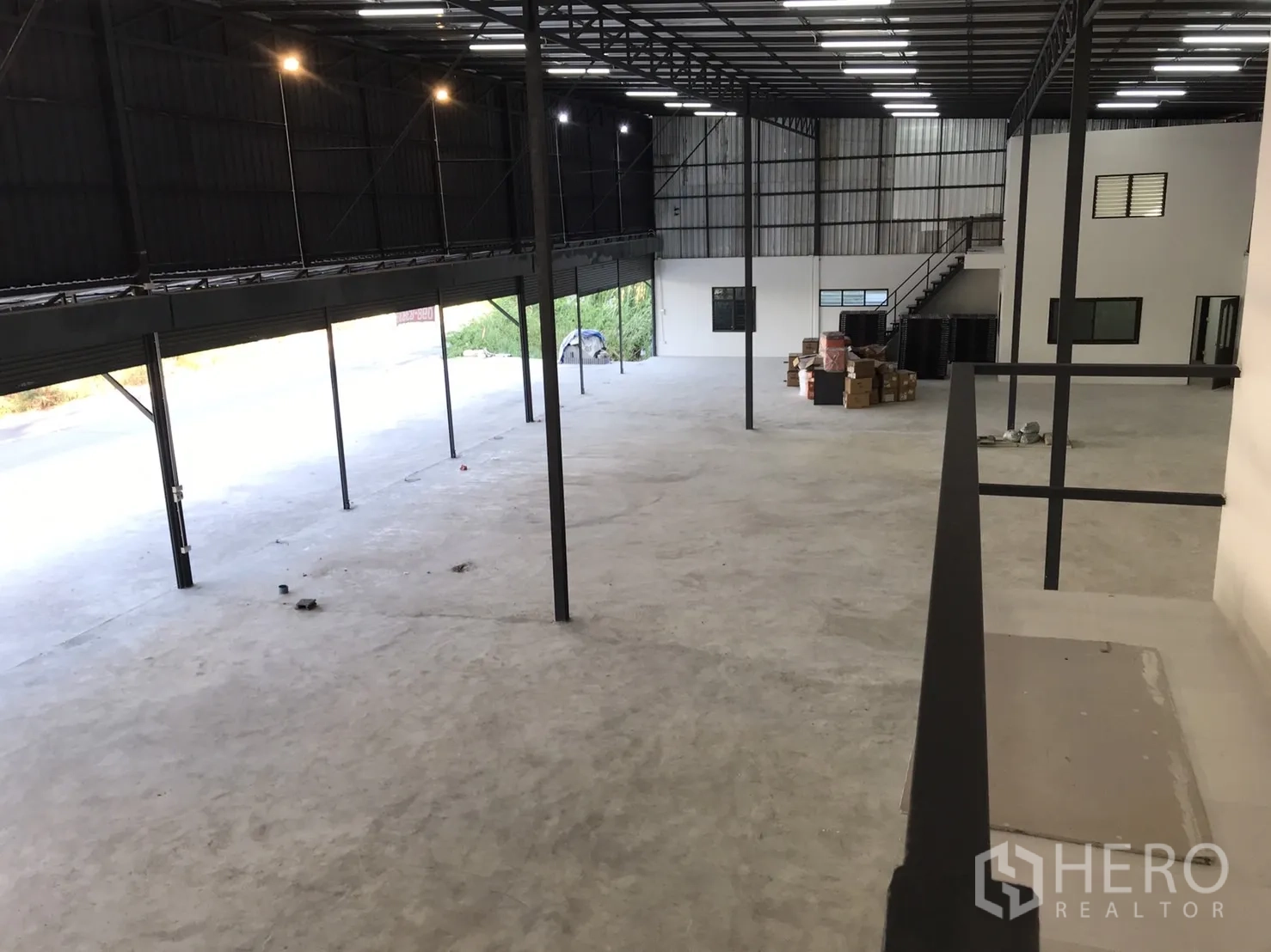 Warehouse for rent in Lam Luk Ka, Pathum Thani - View from mezzanine overlooking large warehouse floor and loading doors.