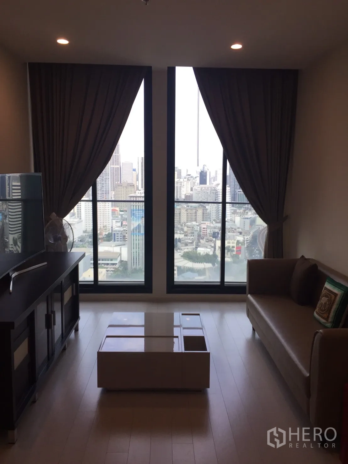 公寓 出租在Pathum Wan, Bangkok - 客厅配落地窗与曼谷天际线景观，沙发与茶几