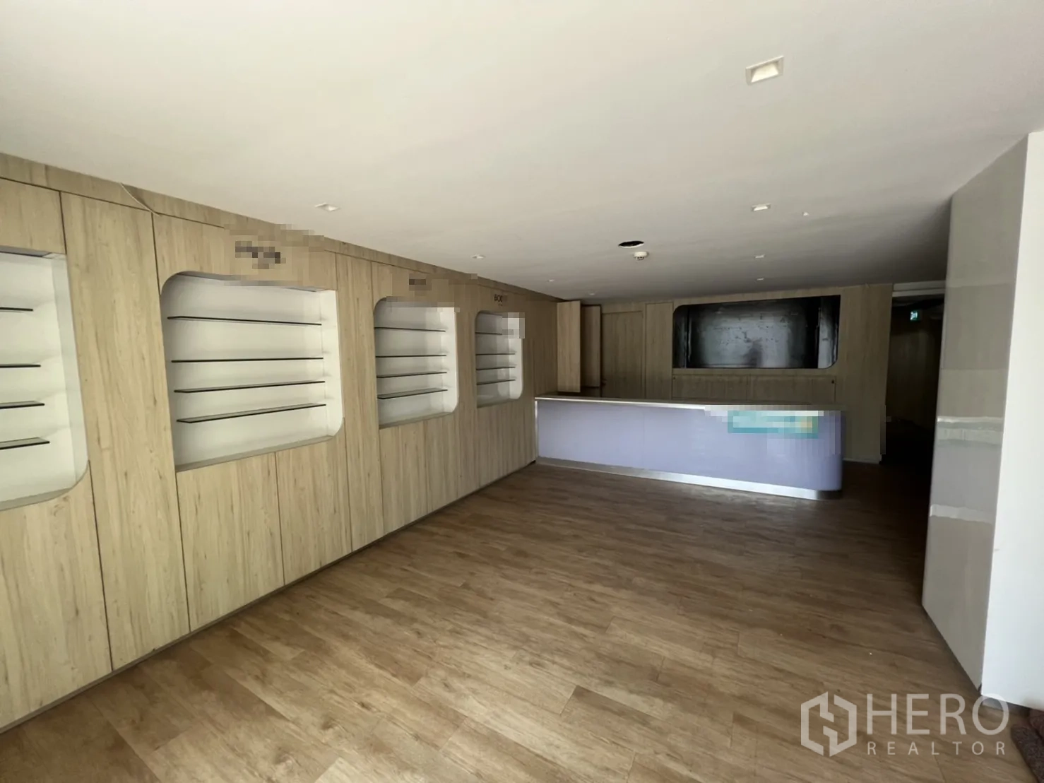 Shophouse for rent or sale in Watthana, Bangkok - Ground-floor showroom featuring product display walls and a long reception counter.