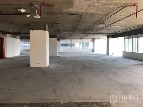 办公空间 出租在Bang Na, Bangkok - 开放式办公室，外露混凝土天花、喷淋管与柱体。