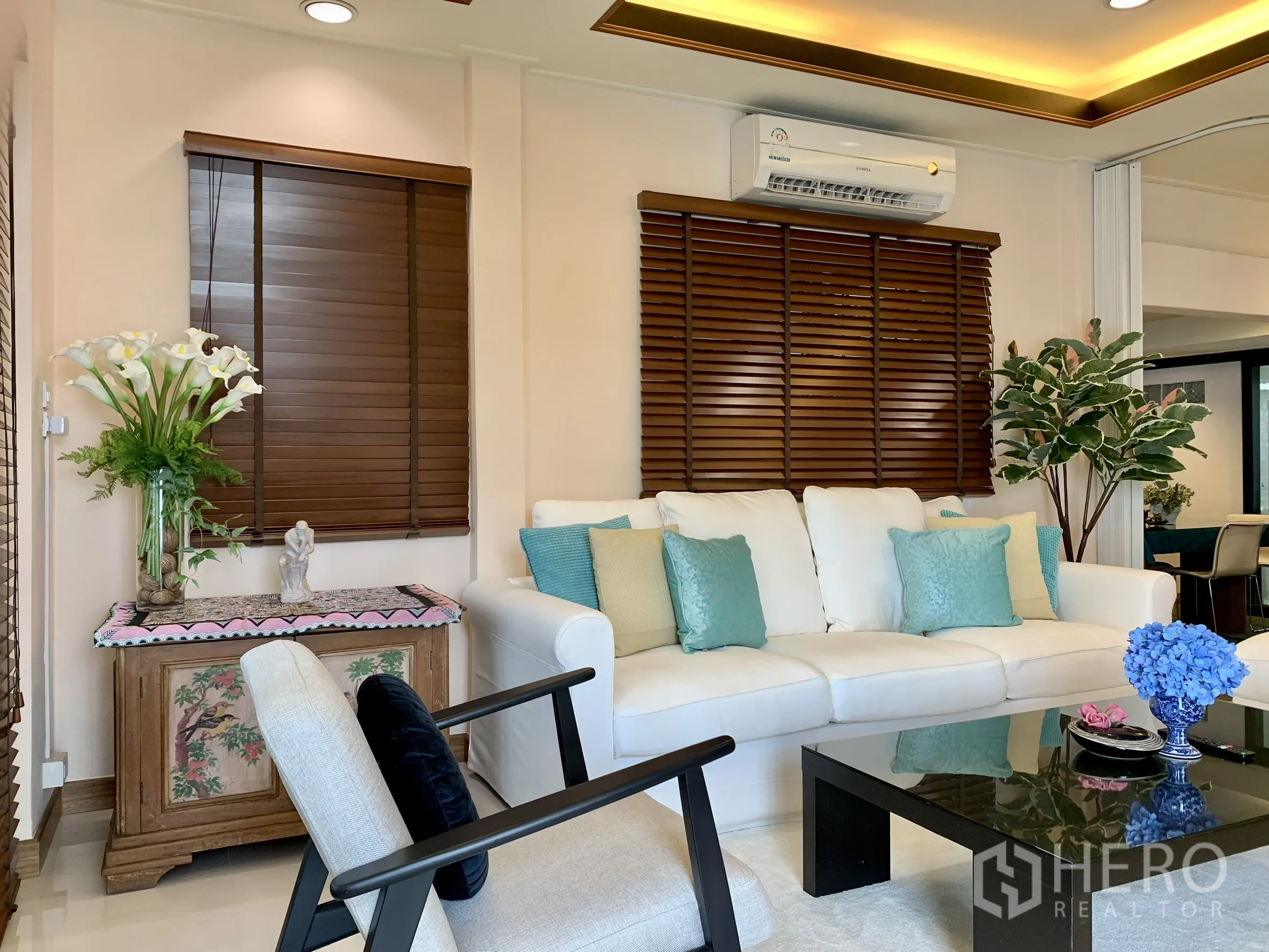 独栋房屋 for rent in Saphan Sung, Bangkok - 客厅视角展示电视墙、座椅、大窗与暖色顶灯。