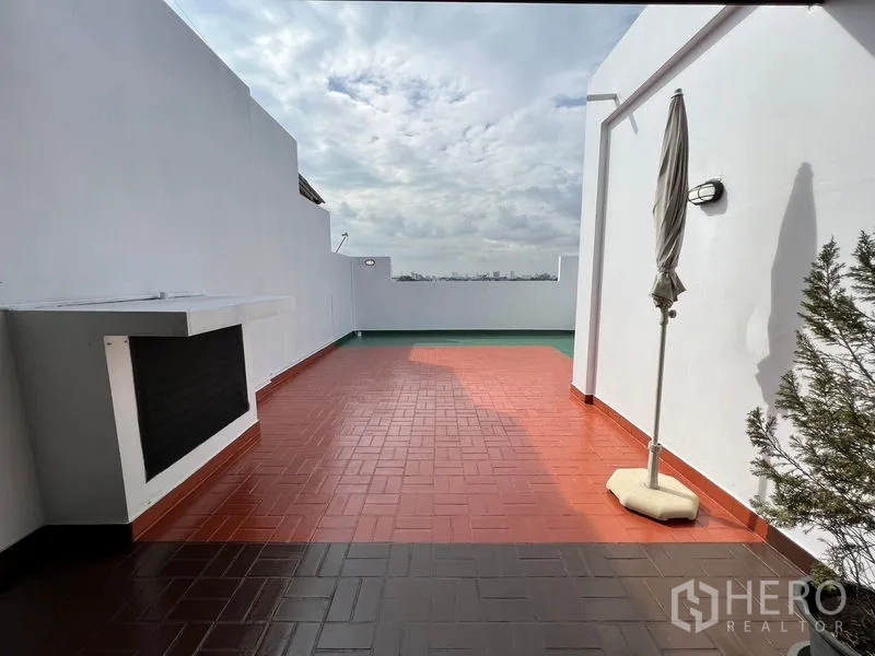 Townhouse for rent or sale in Suan Luang, Bangkok - Private rooftop terrace with red tiles, city outlook and a built-in counter.