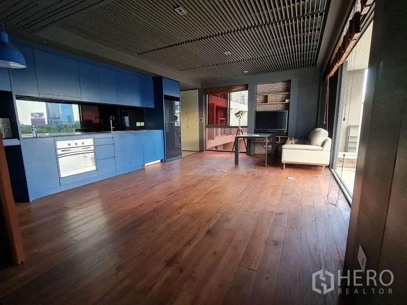 公寓 出售在Pathum Wan, Bangkok - 开放式空间，蓝色整体厨房与大窗户