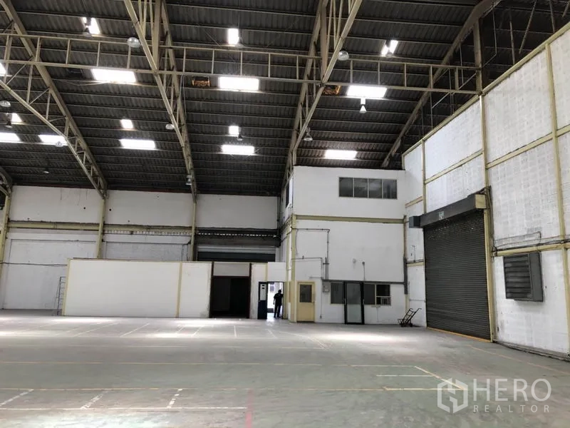 货栈 出租在Mueang Samut Prakan, Samut Prakan - 开阔仓库地面，高挑屋顶，带内部办公区与装卸卷帘门。