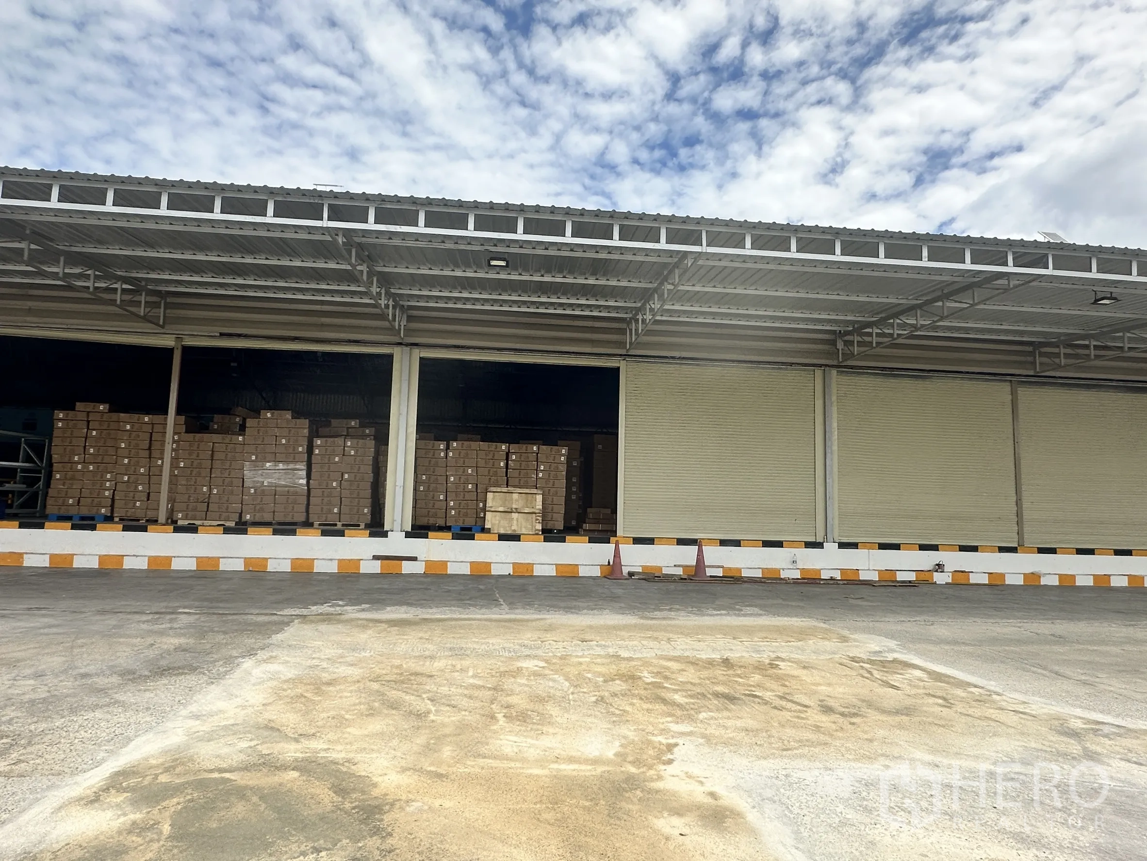工厂 for rent in Lat Krabang, Bangkok - 开放装卸口内可见堆放整齐的纸箱托盘，钢结构屋顶覆盖。