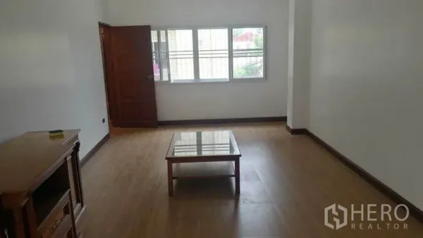 联排别墅 出租在Khlong Toei, Bangkok - 简洁起居室，木地板、带护栏窗户与小茶几。