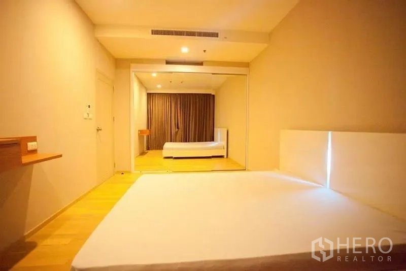 คอนโด ให้เช่าหรือขายในWatthana, Bangkok - ห้องนอนกว้างพื้นไม้ ผนังกระจกบานยาวและแสงไฟนุ่มนวล