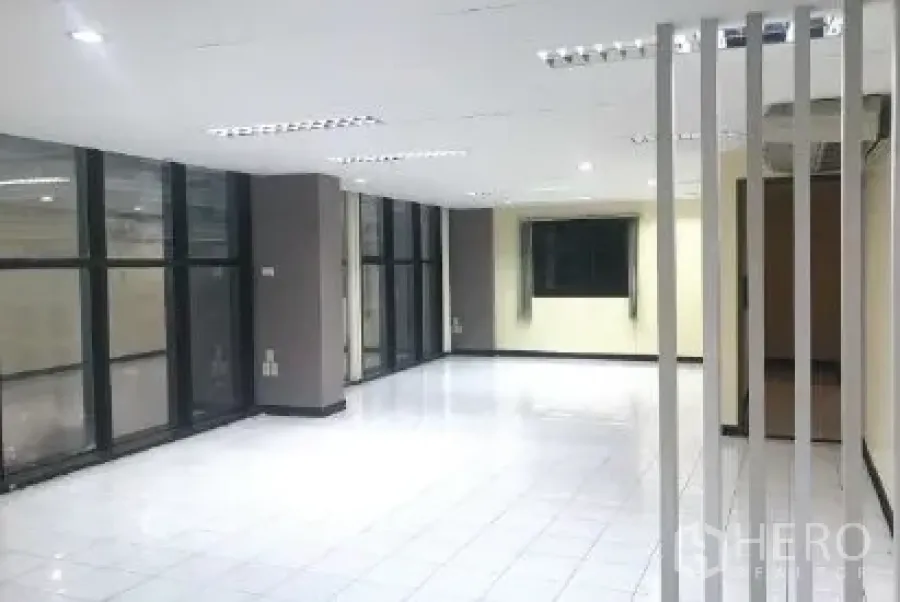 Office Space for rent in Bang Rak, Bangkok - Open office with floor-to-ceiling windows, white tile floors and decorative vertical partitions.