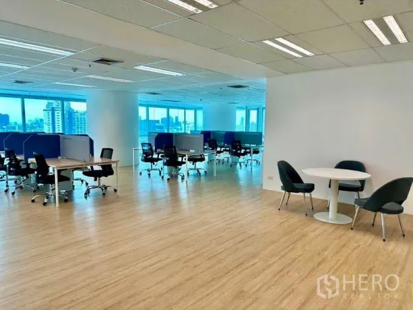 办公空间 出租 - 宽敞办公室楼层，成排工位与圆形协作桌，临大窗可见天际线。