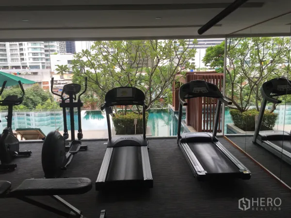 公寓 出租在Watthana, Bangkok - 公寓健身房，跑步机面向景观泳池与绿化。