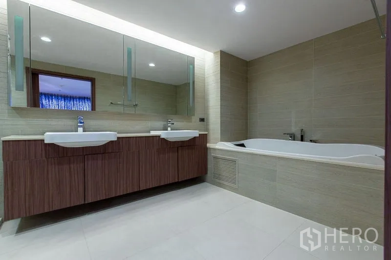 Condominium for sale in Sathon, Bangkok - Contemporary bathroom with double vanity, large mirrors and a soaking tub.