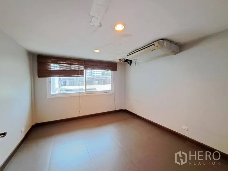 Shophouse for rent in Watthana, Bangkok - Air-conditioned office room with window blinds and tile flooring.