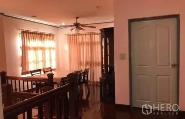 独立式住宅 出租在Khlong Sam Wa, Bangkok - 二楼用餐区，木地板、吊扇与大窗纱帘