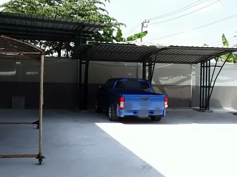 工厂 出租在Saphan Sung, Bangkok - 金属雨棚车位，混凝土场地内停放一辆皮卡。