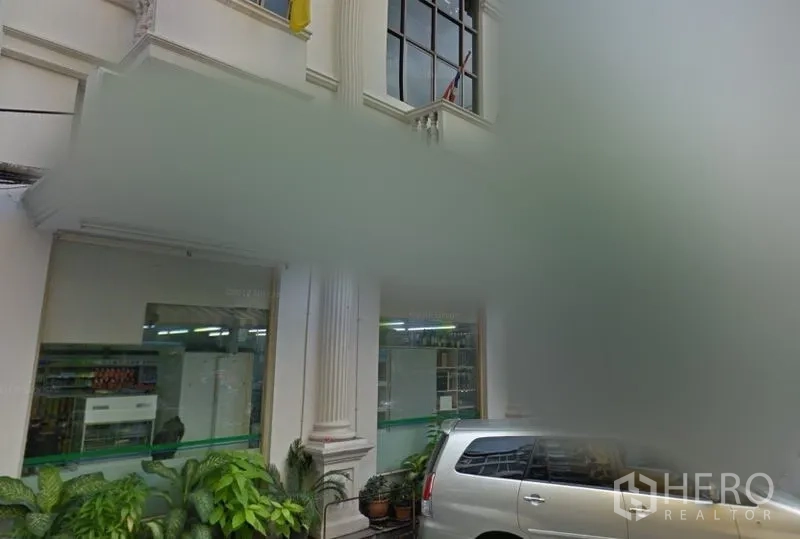 Retail Space for rent in Bang Rak, Bangkok - Street-level retail frontage with tall columns, large glass windows, potted plants and nearby parking in Bang Rak, Bangkok.
