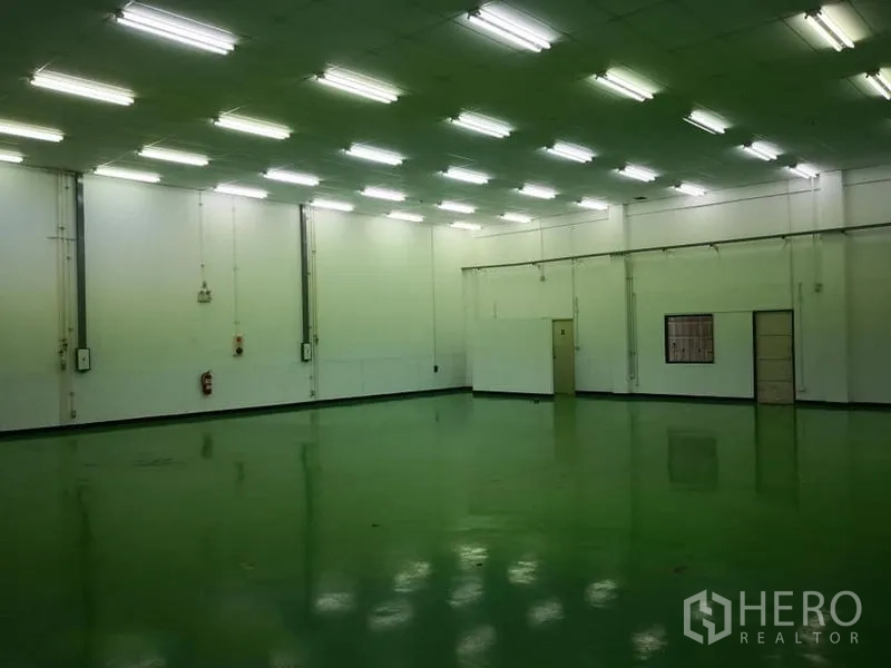 Warehouse for rent in Bang Phli, Samut Prakan - Bright high-ceiling warehouse interior with green epoxy floor and fluorescent lighting in Bang Phli.