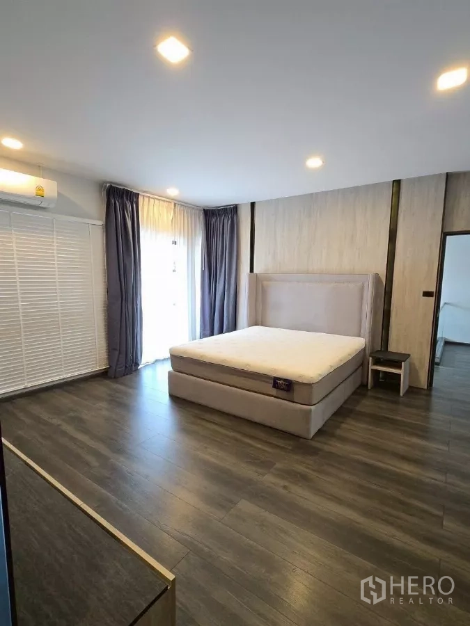 联排别墅 出租在Bang Phli, Samut Prakan - 主卧空间大，软包床、木地板与大窗帘组合。