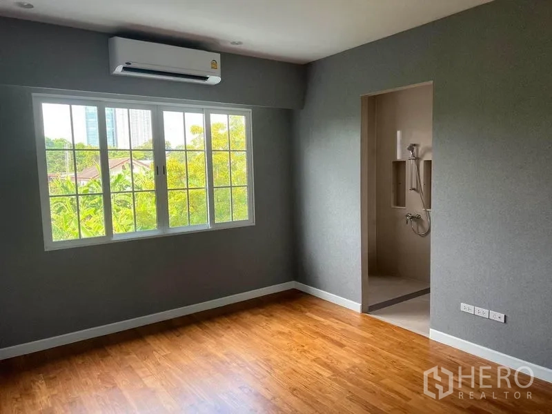 Detached House for sale in Yan Nawa, Bangkok - Bedroom with wood flooring, wide window and doorway to an ensuite.