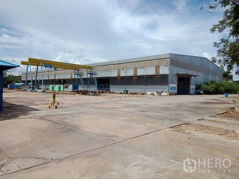Factory for sale in Chachoengsao - Side elevation of the warehouse with gantry cranes and an expansive marked loading apron.