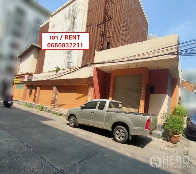 Retail Space for rent in Watthana, Bangkok - Street-facing commercial building with roller shutter entrance and a pickup truck parked outside.